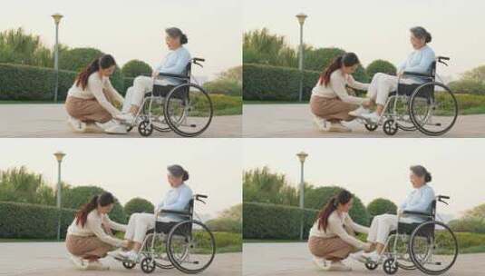 女儿为坐轮椅的母亲按摩康复身体高清在线视频素材下载