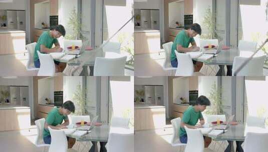 十几岁的亚洲男孩在现代家庭餐桌上用笔记本高清在线视频素材下载