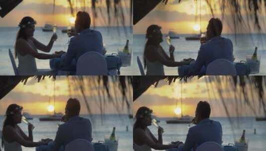 日落时海滩上情侣在喝香槟高清在线视频素材下载