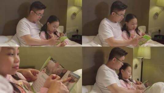 父亲抱着孩子看书给孩子讲睡前故事父女看书高清在线视频素材下载