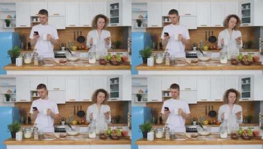 年轻夫妇在厨房使用手机高清在线视频素材下载