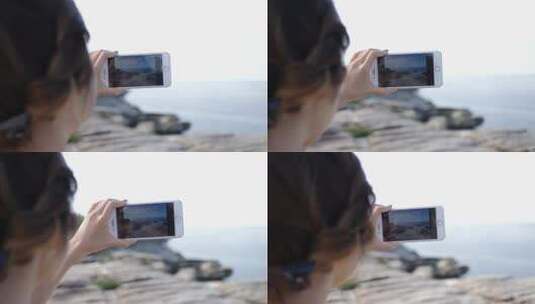 一个女人用手机拍摄海洋景观高清在线视频素材下载
