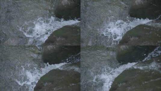 水从岩石上摔下来掉进水池的慢动作镜头。高清在线视频素材下载