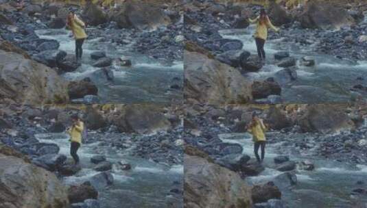 女孩站在河边的岩石上跳舞高清在线视频素材下载