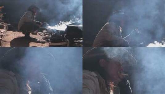 一个牛仔坐在火边抽烟高清在线视频素材下载
