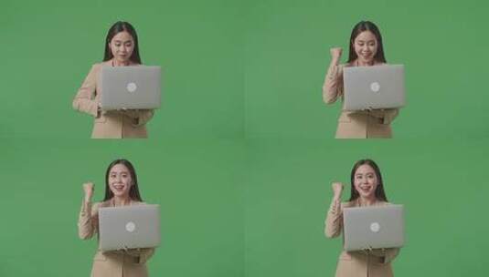 快乐的亚洲女商人在工作室的绿屏上庆祝使用笔记本电脑高清在线视频素材下载