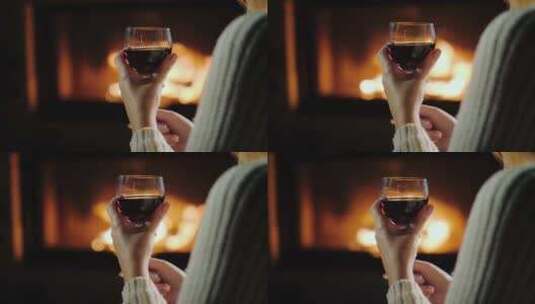 4K-壁炉背景下手持红酒杯的女性高清在线视频素材下载