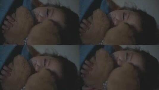 小女孩晚上躺在床上抱着她的泰迪熊睡觉高清在线视频素材下载