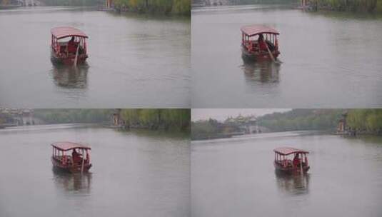 扬州瘦西湖阴雨天在雨中行驶的摇橹船及船娘高清在线视频素材下载
