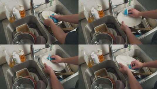 男人在厨房的脏水槽里用手洗碗高清在线视频素材下载