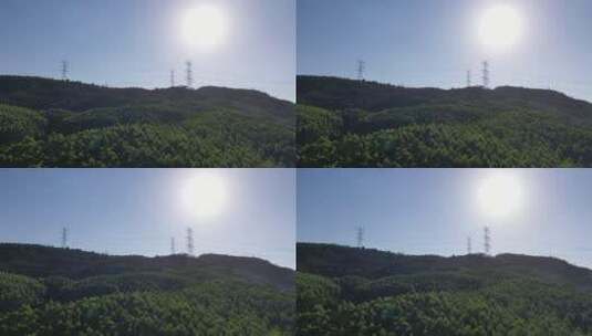 阳光下电塔航拍山上电网森林山区电线电力塔高清在线视频素材下载