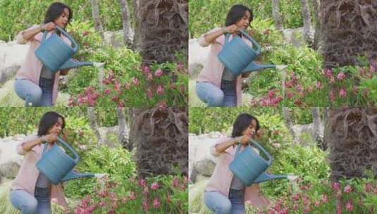快乐的混血儿女人园艺，用喷壶给植物浇水高清在线视频素材下载
