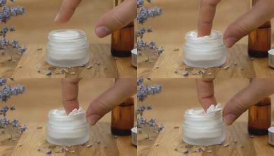 女人用手指从玻璃罐中取出白色面霜。美丽与健康的概念高清在线视频素材下载
