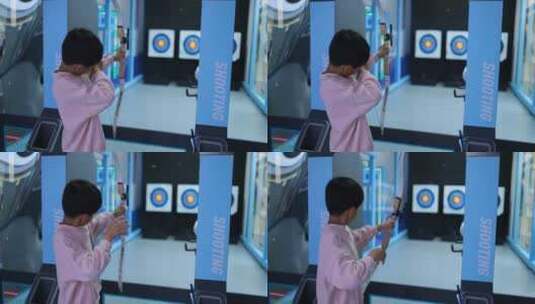 男孩在室内游乐场练习射箭高清在线视频素材下载