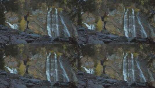 女人拿相机拍摄瀑布美景高清在线视频素材下载