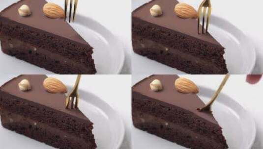 用叉子把一块巧克力蛋糕放在黑色盘子里吃。高清在线视频素材下载