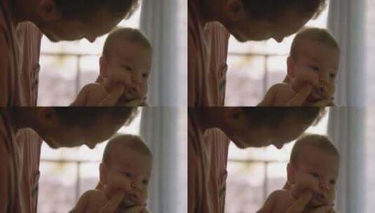 父亲用手指擦掉婴儿脸上的牛奶高清在线视频素材下载
