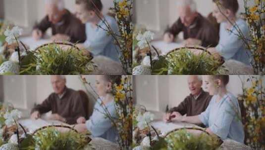 女人和一个老人坐在一起，在室内的桌子上写高清在线视频素材下载