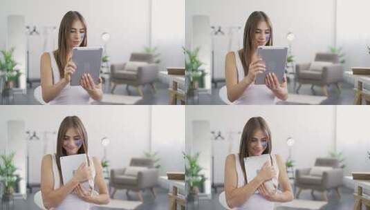 年轻可爱女人坐在家里从平板电脑上得到好消息的肖像高清在线视频素材下载
