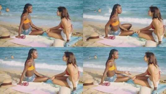 两个女孩坐在阳光沙滩上高清在线视频素材下载