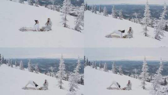 一个男人祈祷，而一个女人正在积雪覆盖的山高清在线视频素材下载