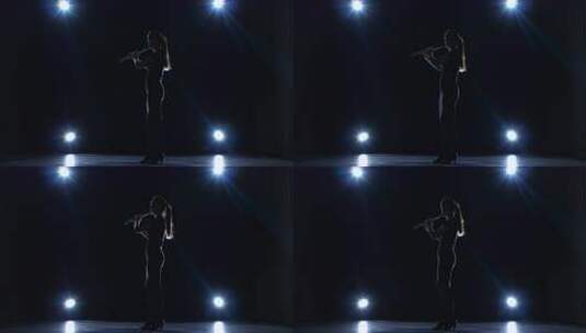 聚光灯下黑暗工作室的音乐家演奏长笛缓慢的高清在线视频素材下载