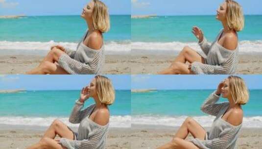 穿着灰色毛衣的女人坐在沙滩上高清在线视频素材下载