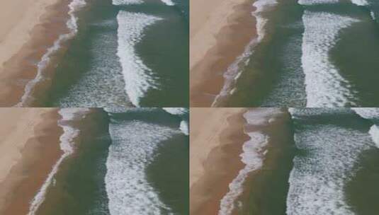 航拍海岸边的海浪冲向沙滩高清在线视频素材下载