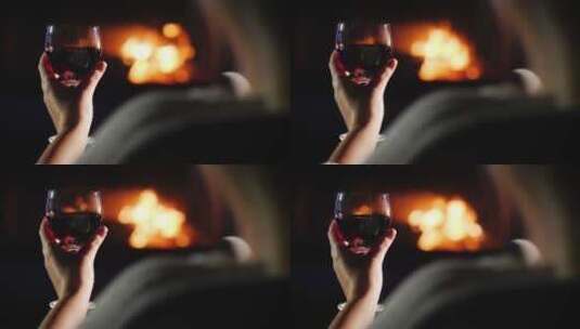 女孩坐在壁炉旁喝红酒高清在线视频素材下载