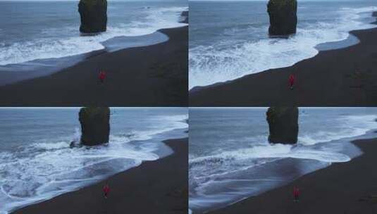 穿着红色夹克的女人在冰岛的莱克贾维克海滩高清在线视频素材下载