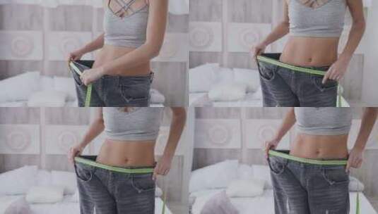 健身减肥的女生在测量裤子的腰围高清在线视频素材下载