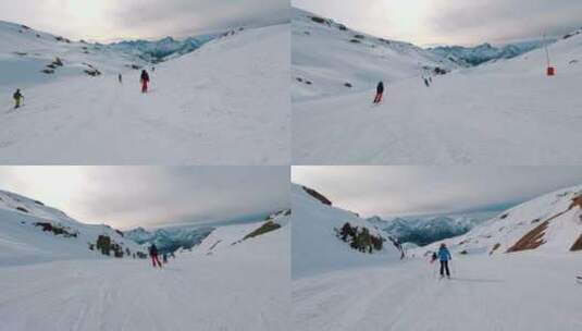 人们在以美丽雪山为背景的斜坡上滑雪高清在线视频素材下载