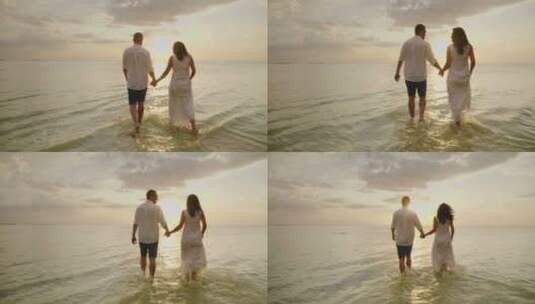 年轻夫妇在海边漫步看日落高清在线视频素材下载