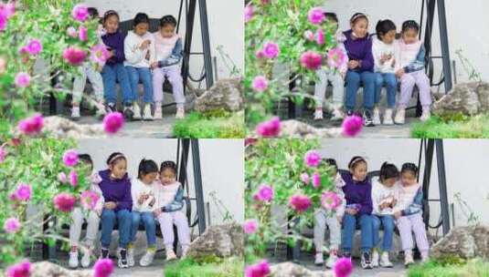 4K实拍在开满鲜花的院子里荡秋千的四个女孩高清在线视频素材下载