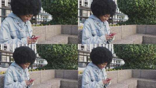 年轻的非裔美国妇女坐在户外使用手机高清在线视频素材下载