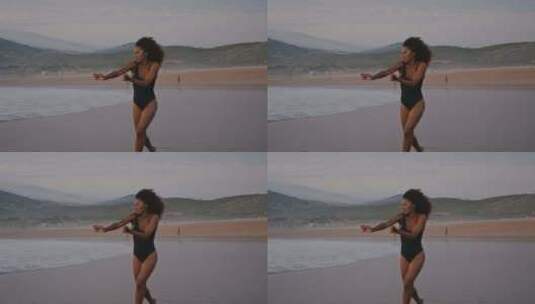 阴郁天空中跳舞的现代海滩女人高清在线视频素材下载