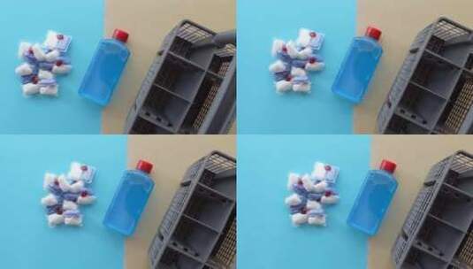 蓝色背景上的一堆洗碗机药片和一瓶洗涤剂高清在线视频素材下载