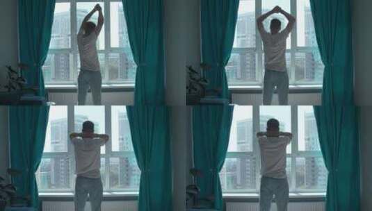 清晨，男人锻炼的剪影，在家靠窗伸展身体。高清在线视频素材下载