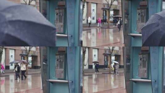下雨天上海南京路电话亭旁行人撑伞走过高清在线视频素材下载