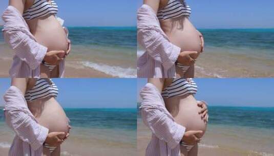 怀孕的性感女子站在海滩上摸自己的肚子高清在线视频素材下载
