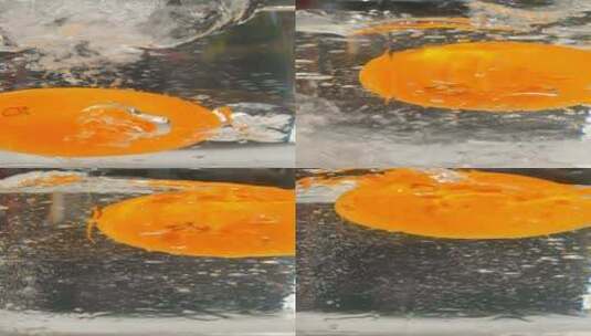 一颗橙子，掉进水杯里的特写慢镜头高清在线视频素材下载