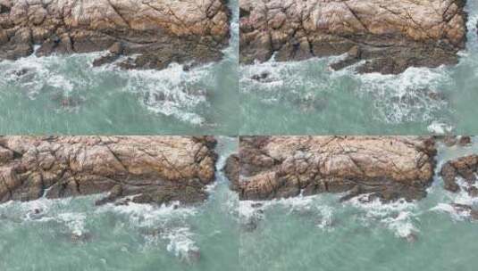 俯拍海岸礁石沙滩海水拍打岩石浪花潮水冲刷高清在线视频素材下载