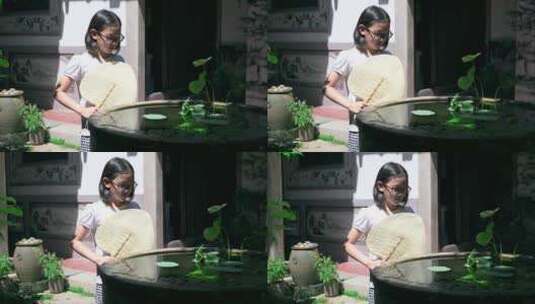 4K升格实拍在中式庭院鱼缸边乘凉的女孩高清在线视频素材下载