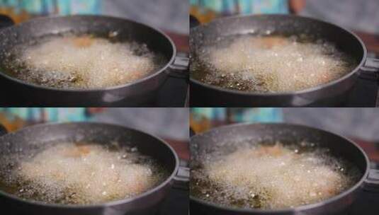 烹饪油在浅锅中沸腾的慢动作特写高清在线视频素材下载