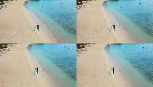 航拍情侣穿婚纱走在海边海滩上高清在线视频素材下载