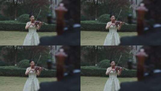 美女小提琴和外国人大提琴住宅小区草坪演奏高清在线视频素材下载