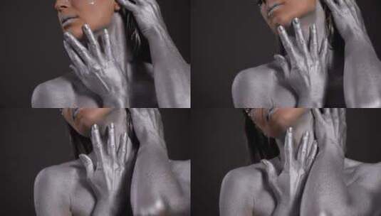 黑色背景下银色皮肤和双手的女性模特特写高清在线视频素材下载