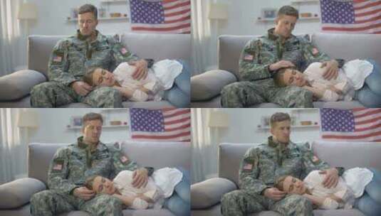 心烦意乱的美国士兵抚摸睡在沙发上的女朋友，兵役高清在线视频素材下载