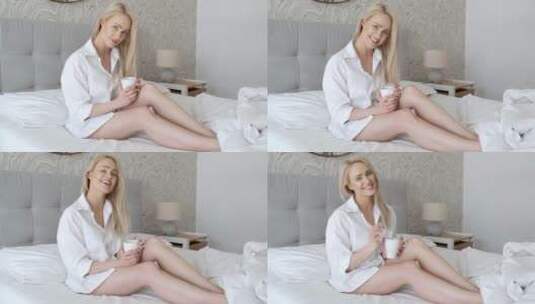 女人端着咖啡坐在床上高清在线视频素材下载
