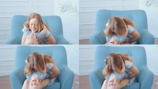 母亲在沙发上抱着孩子玩耍高清在线视频素材下载